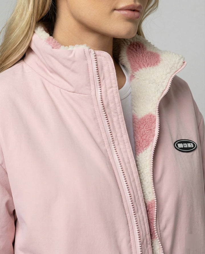 Detailansicht des Reißverschlusses und Herz-Fleecekragens der rosa Jacke