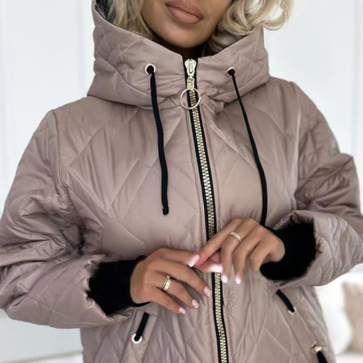 Nahaufnahme des goldfarbenen Reißverschlusses an rosa Steppjacke