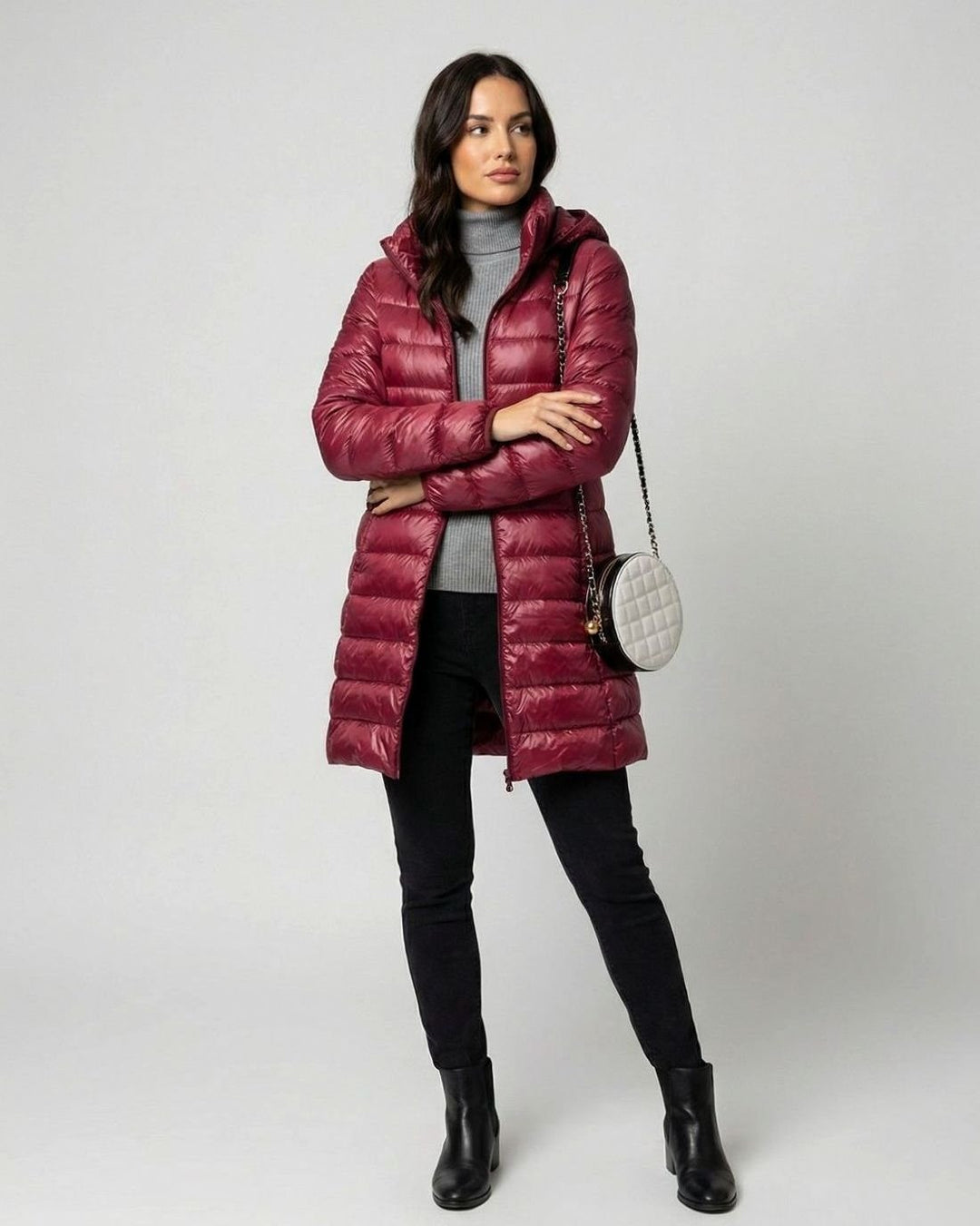 Bordeauxrote Steppjacke mit Kapuze, kombiniert mit grauem Rollkragenpullover und Umhängetasche