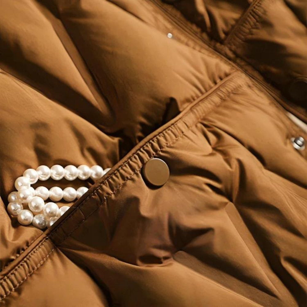 Detailansicht Druckknopf und Rautensteppung einer braunen Daunenjacke
