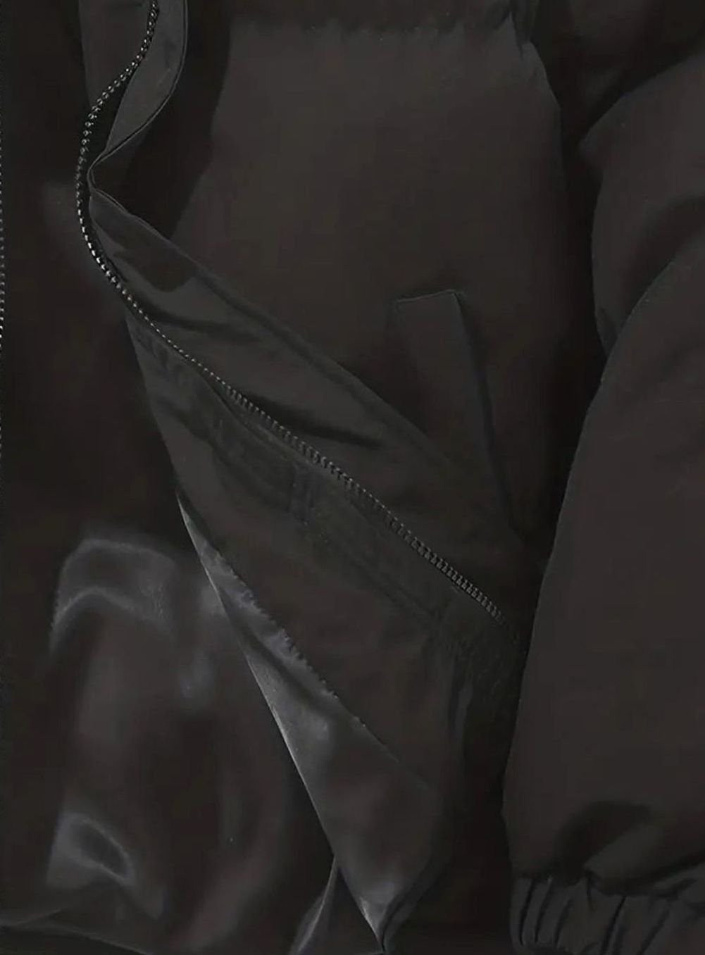 Innentasche mit Reißverschluss der schwarzen Winterjacke im Detail
