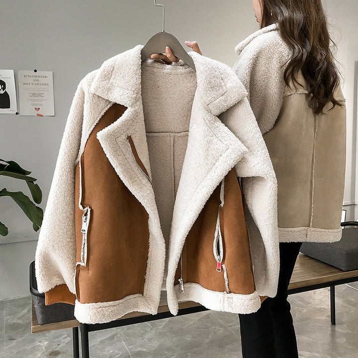 Karamellbraune Winterjacke mit cremefarbenem Teddyfell-Kragen auf Kleiderbügel