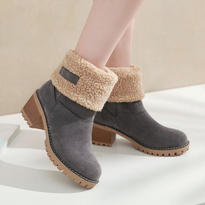 Graue Winterstiefel mit Kunstfellkragen und Blockabsatz, am Fuß getragen