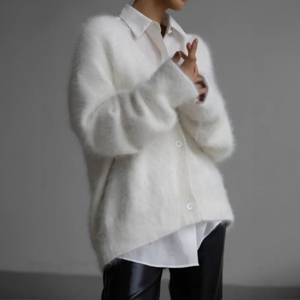 Cremeweiße flauschige Strickjacke über weißem Hemd getragen
