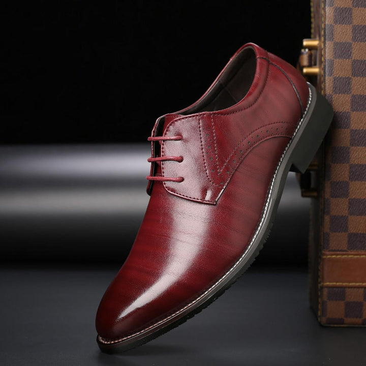 Herren Schnürschuh aus bordeauxrotem Leder mit schmaler Spitze und Brogue-Details