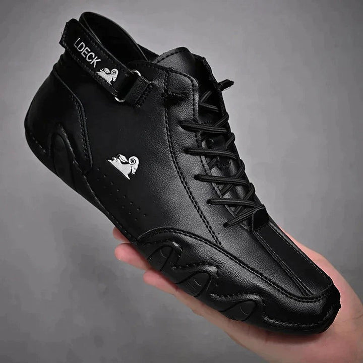 Schwarzer Leder-Barfußschuh mit dünner Profilsohle in Handfläche präsentiert