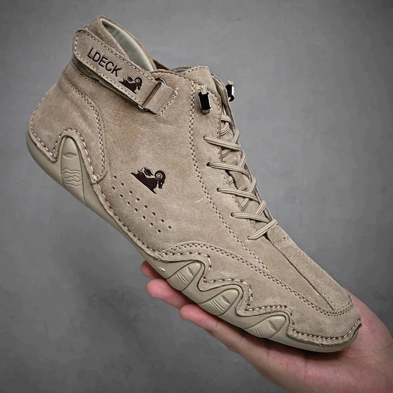 Beiger Wildleder-Barfußschuh mit Klettverschluss und Wellensohle in Hand gehalten