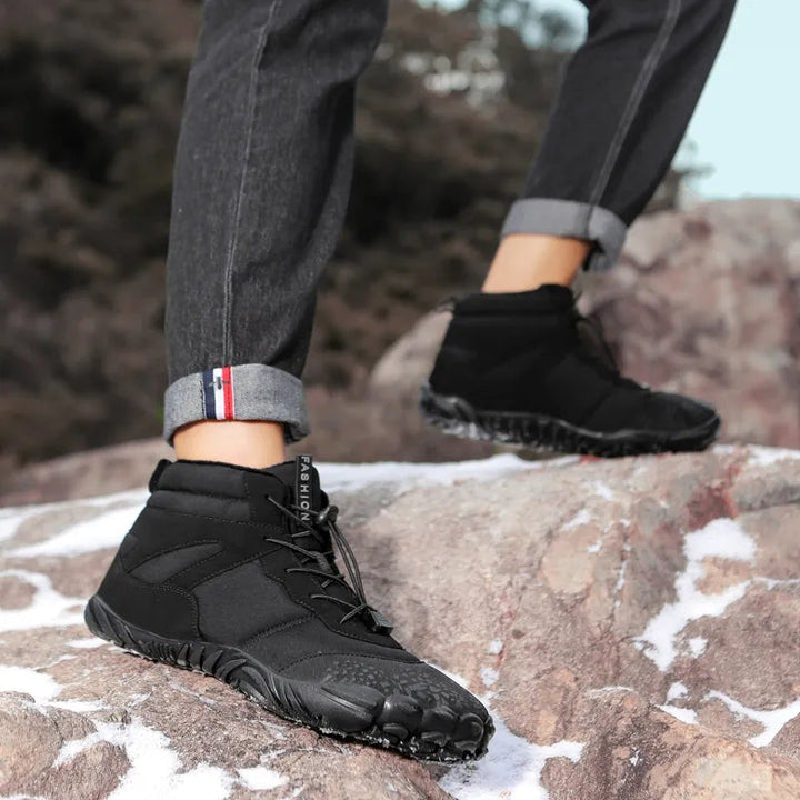 Barfuß Winterschuh schwarz mit Zehenprofil beim Klettern auf Felsen