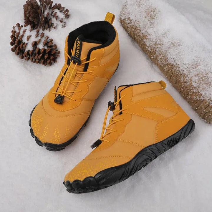 Gelbe Barfuß Winterboots mit Zehenmuster im Schnee platziert