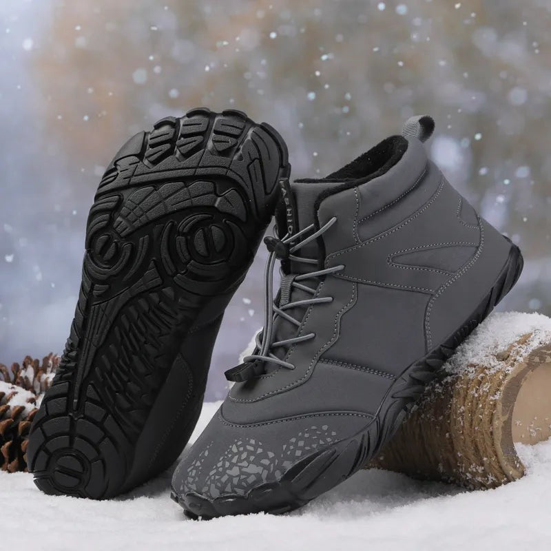 Graue Winterboots mit auffälliger Profilsohle im Schnee stehend