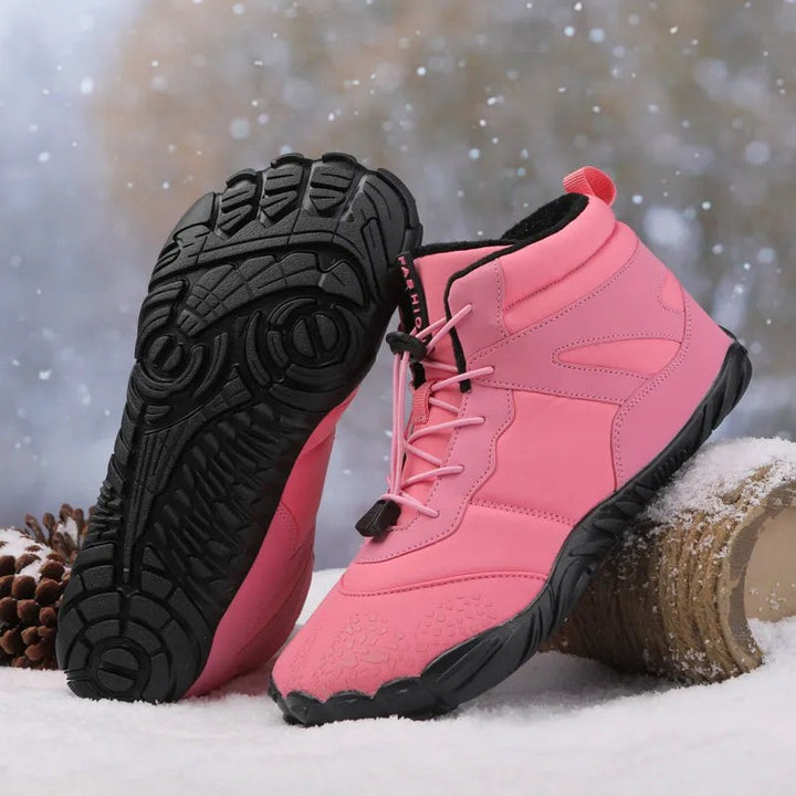 Pinke Winterboots mit schwarzer Profilsohle im Schneehintergrund