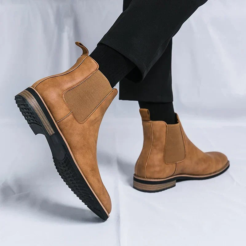 Cognacfarbener Chelsea-Stiefel aus Leder in Schrittbewegung fotografiert