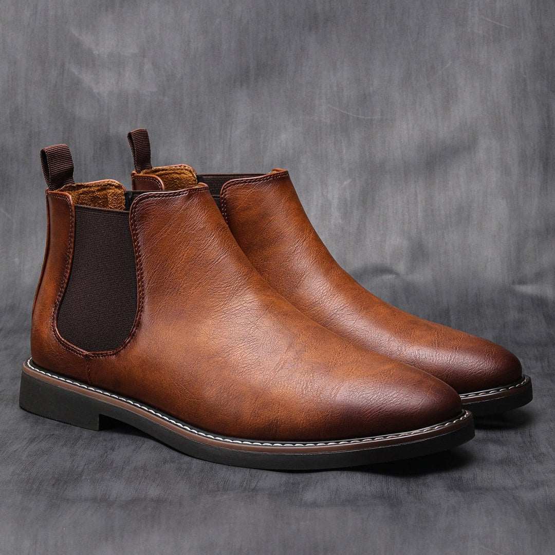 Paar braune Chelsea Lederstiefel mit robuster Gummisohle im Studio
