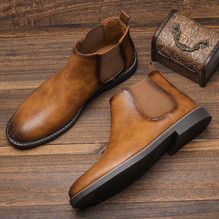 Cognacfarbene Chelsea Boots mit Kontrastnaht auf Holzuntergrund präsentiert