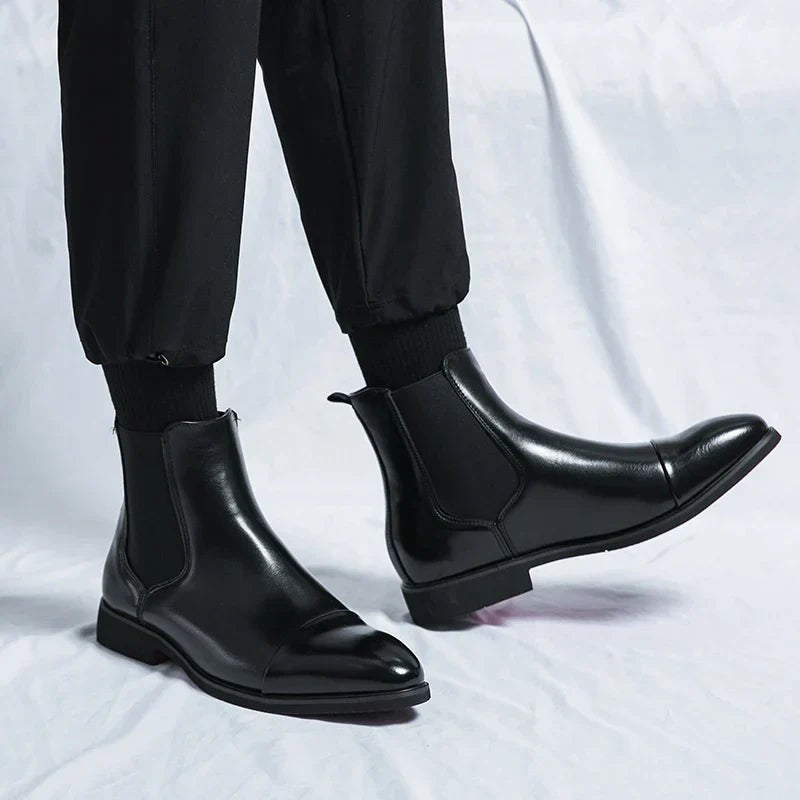 Herren trägt schwarze Chelsea-Stiefel aus Leder zu schwarzer Jogginghose