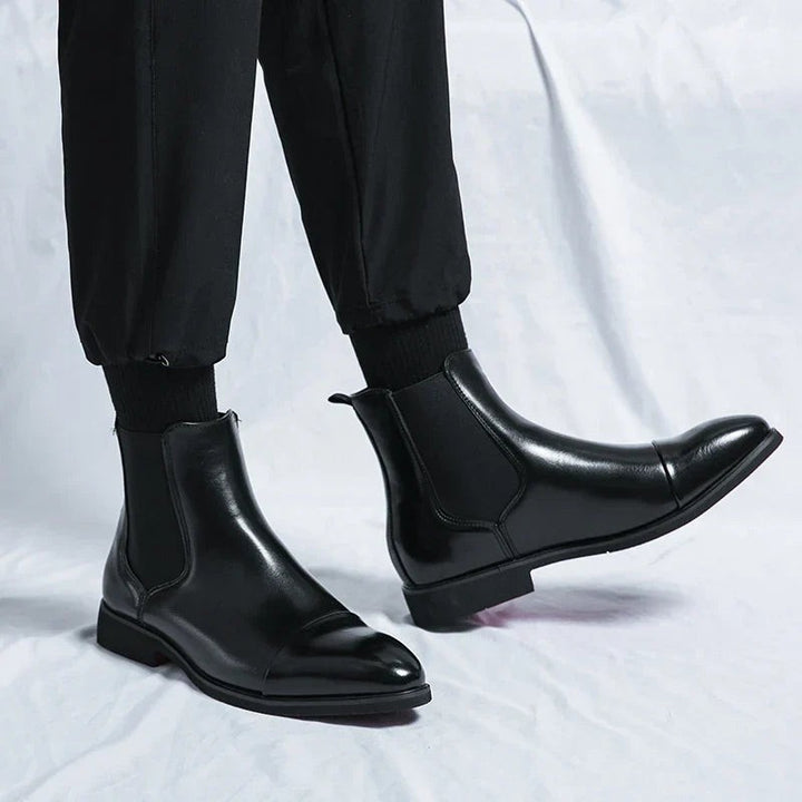 Herren trägt schwarze Chelsea-Stiefel aus Leder zu schwarzer Jogginghose