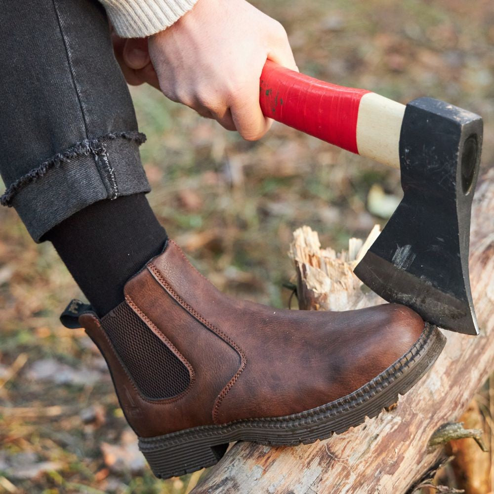 Braune Chelsea-Boots im Einsatz beim Holzhacken mit Axt im Freien