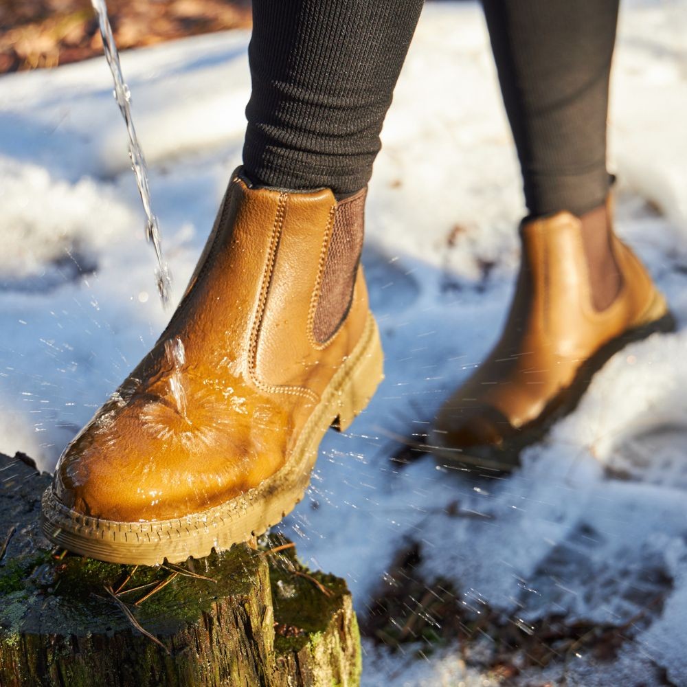 Wasserabweisende Chelsea-Boots in Cognacbraun beim Barfußtest im Schnee
