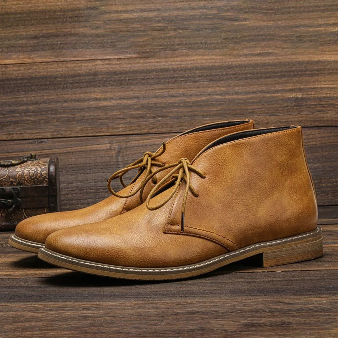 Cognacfarbene Herren Chukka Boots aus Leder mit Schnürung auf Holzboden
