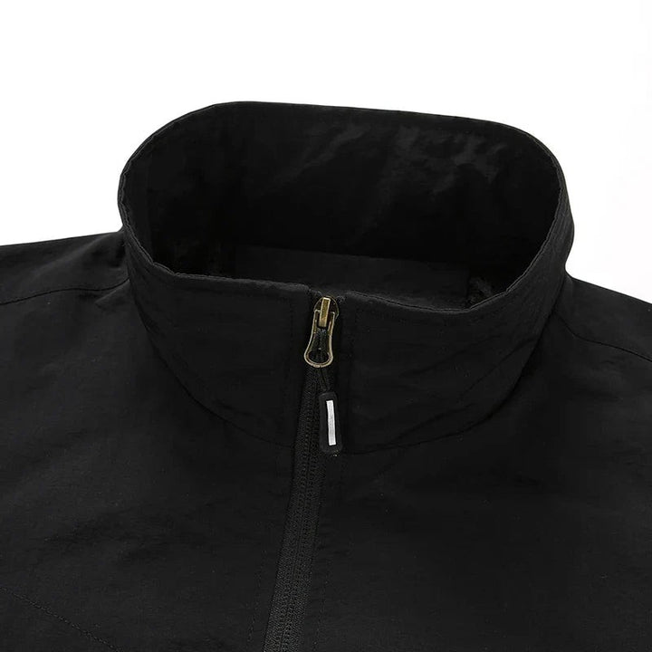 Nahaufnahme des Stehkragens einer schwarzen Fieldjacke mit Metallreißverschluss