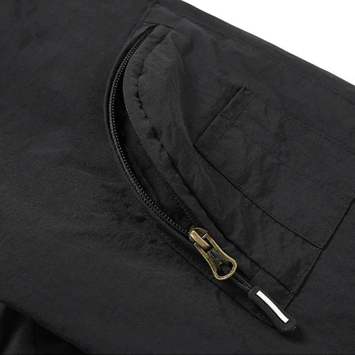 Detailansicht der Ärmeltasche mit Reißverschluss an schwarzer Fieldjacke