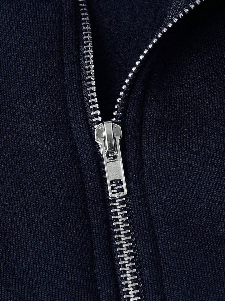 Nahaufnahme des silbernen Reißverschlusses am marineblauen Troyerpullover