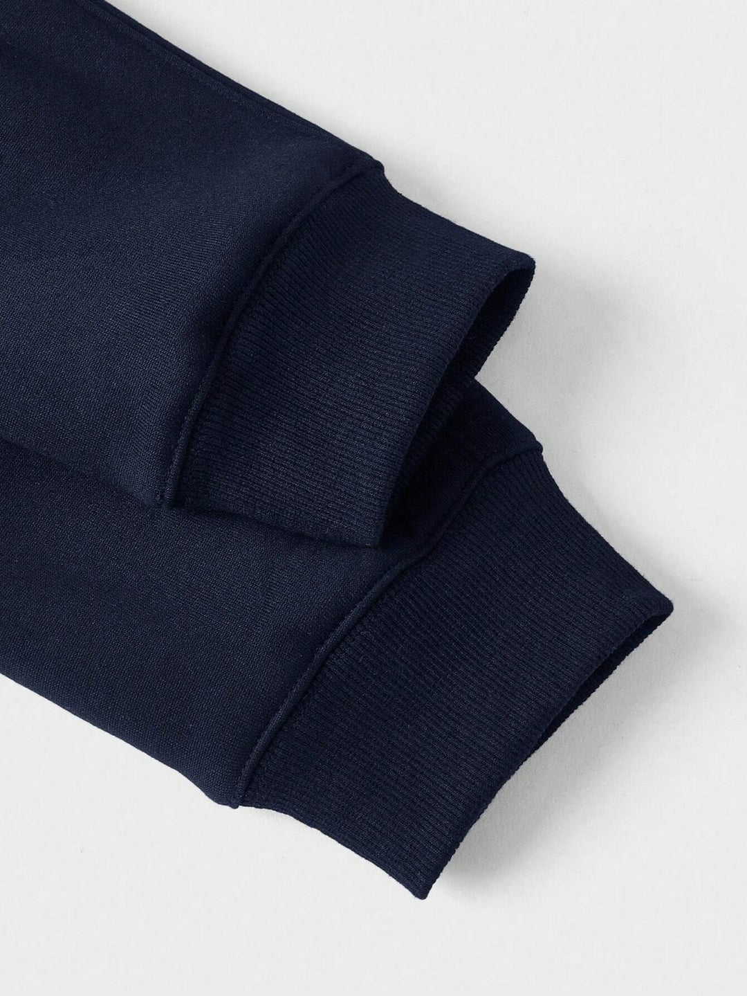 Detailansicht der geripptes Bündchen an den Ärmeln des marineblauen Pullovers