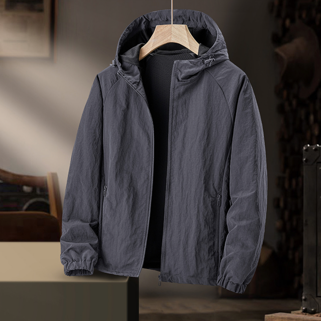 Graue Herren-Windjacke mit Kapuze und Netzfutter auf Kleiderbügel