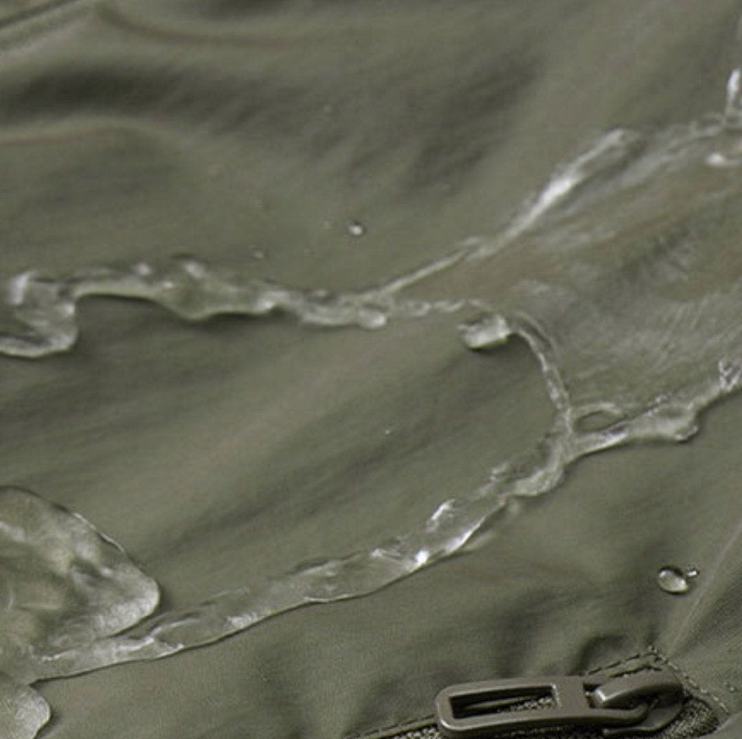 Wassertropfen auf wasserabweisendem Stoff der Windjacke