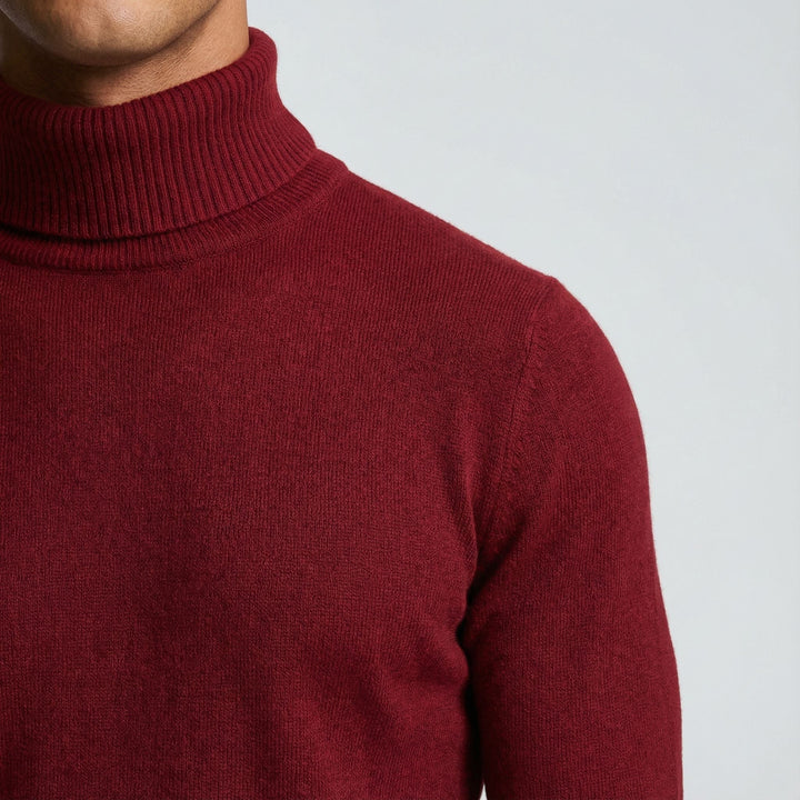 Detailaufnahme des Rollkragens eines weinroten Feinstrickpullovers