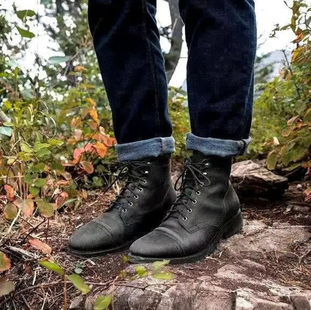 Schwarze Herren Schnürstiefel aus Leder mit robuster Gummisohle im Wald