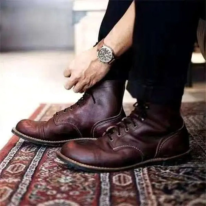 Dunkelbraune Lederstiefel mit Schnürung, getragen zu schwarzer Hose