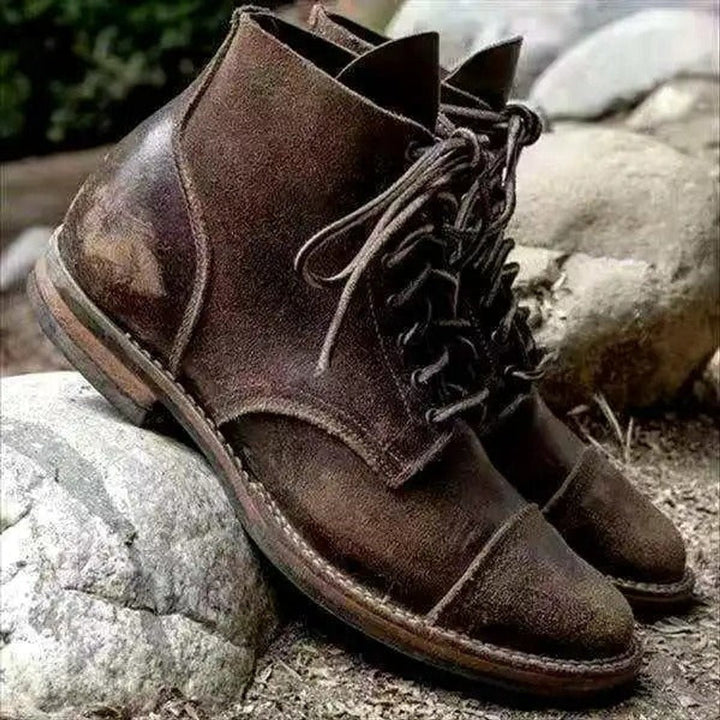 Braune Vintage-Schnürstiefel aus Leder mit robuster Sohle auf Steinen