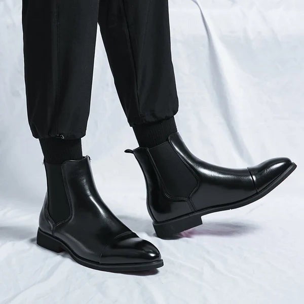 Schwarze Chelsea Boots aus Leder mit spitzer Kappe am Fuß getragen