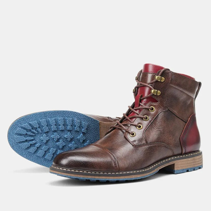Paar braune Lederstiefeletten mit roten Akzenten und auffälliger blauer Sohle