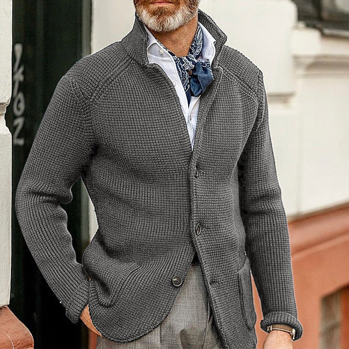 Anthrazitfarbene Strickjacke mit Stehkragen, getragen zu grauer Anzughose