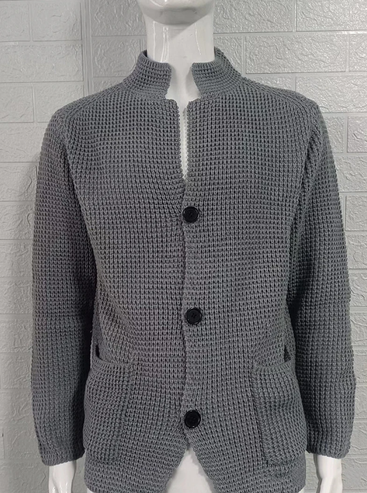 Graue Strickjacke auf Schneiderpuppe mit Stehkragen, Knopfleiste und aufgesetzten Taschen