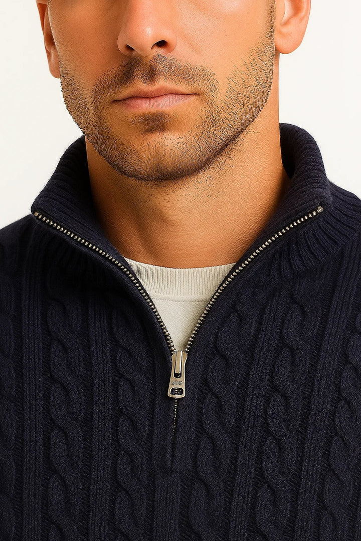 Nahaufnahme des Reißverschlusskragens am dunkelblauen Zopfmuster-Pullover