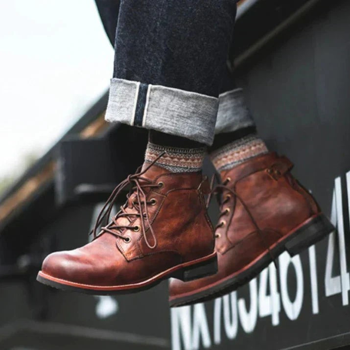 Zwei braune Lederstiefel mit Schnürung, hängend über Container-Kante