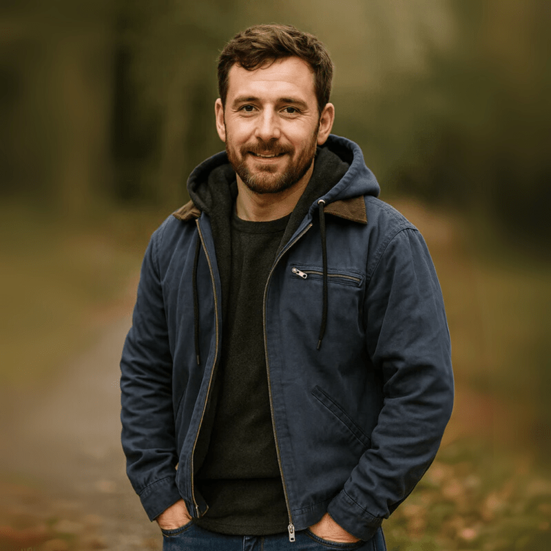 Mann im Wald trägt blaue Winterjacke mit Kapuze