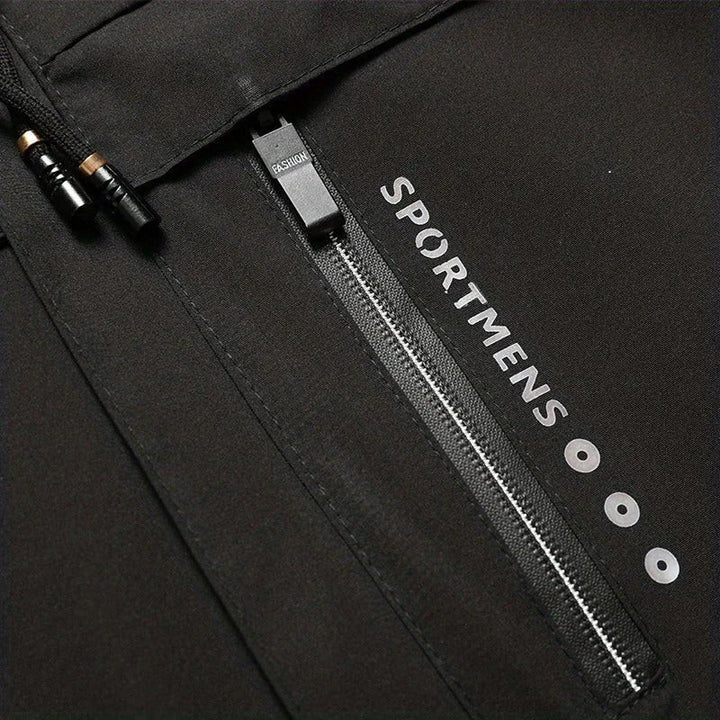 Nahaufnahme Reißverschlusstasche mit Sportmens-Schriftzug an schwarzer Jacke