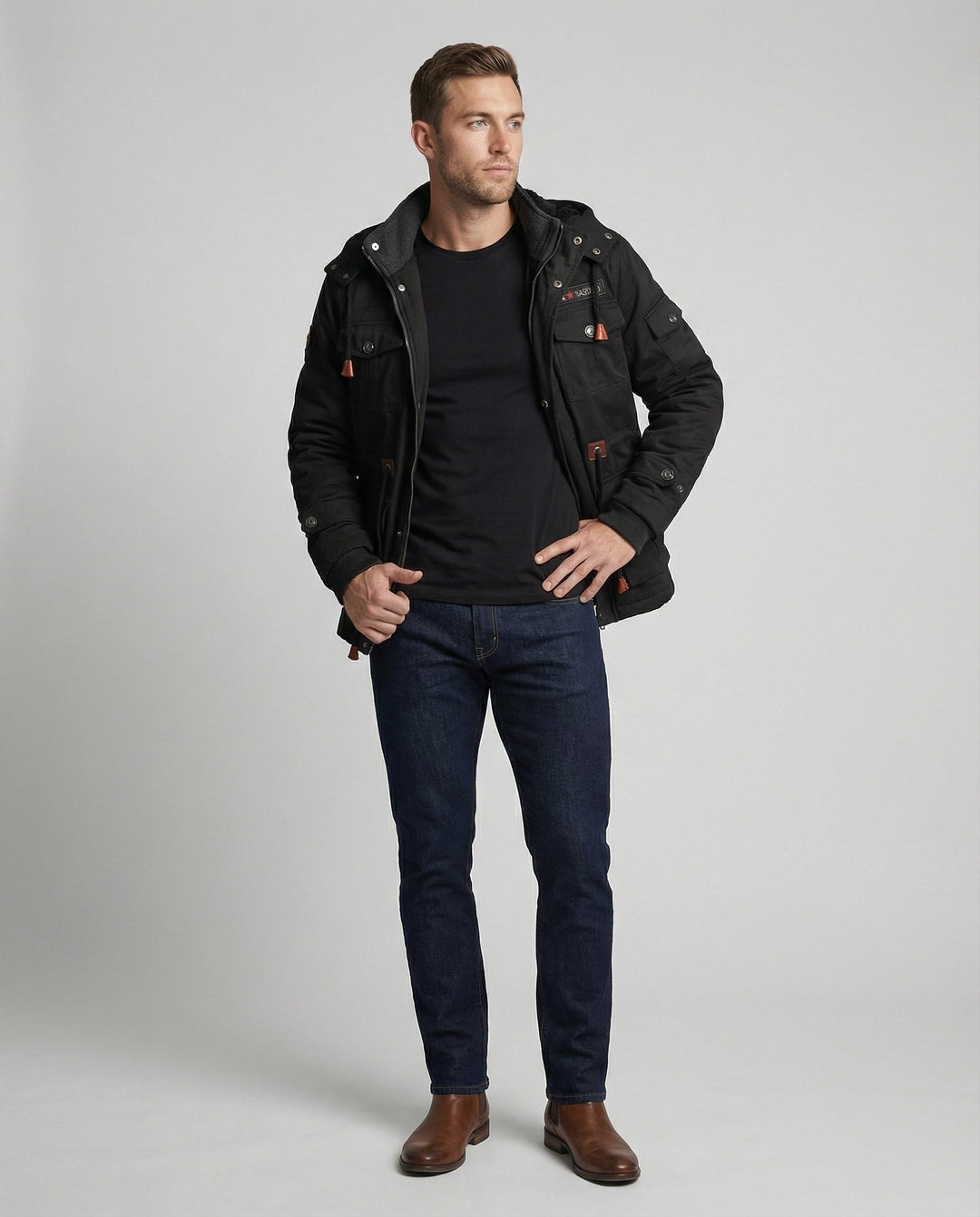 Herren-Winterjacke schwarz kombiniert mit dunkler Jeans und braunen Boots