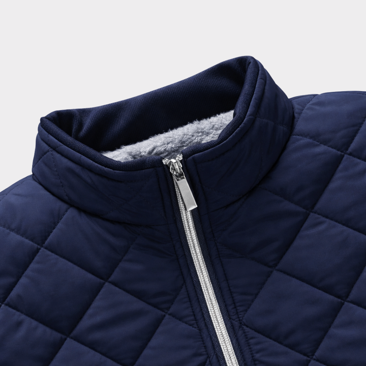 Nahaufnahme Stehkragen und Reißverschluss einer marineblauen Steppjacke